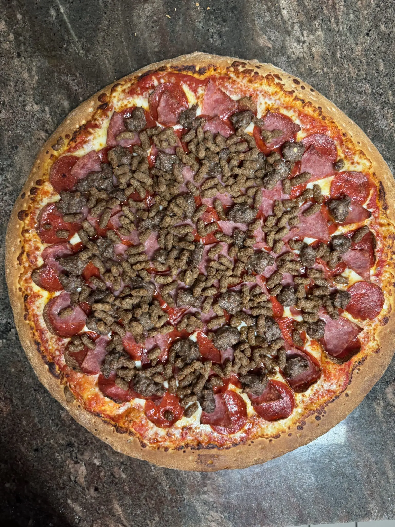 A pepperoni and sausage pizza with a golden crust.