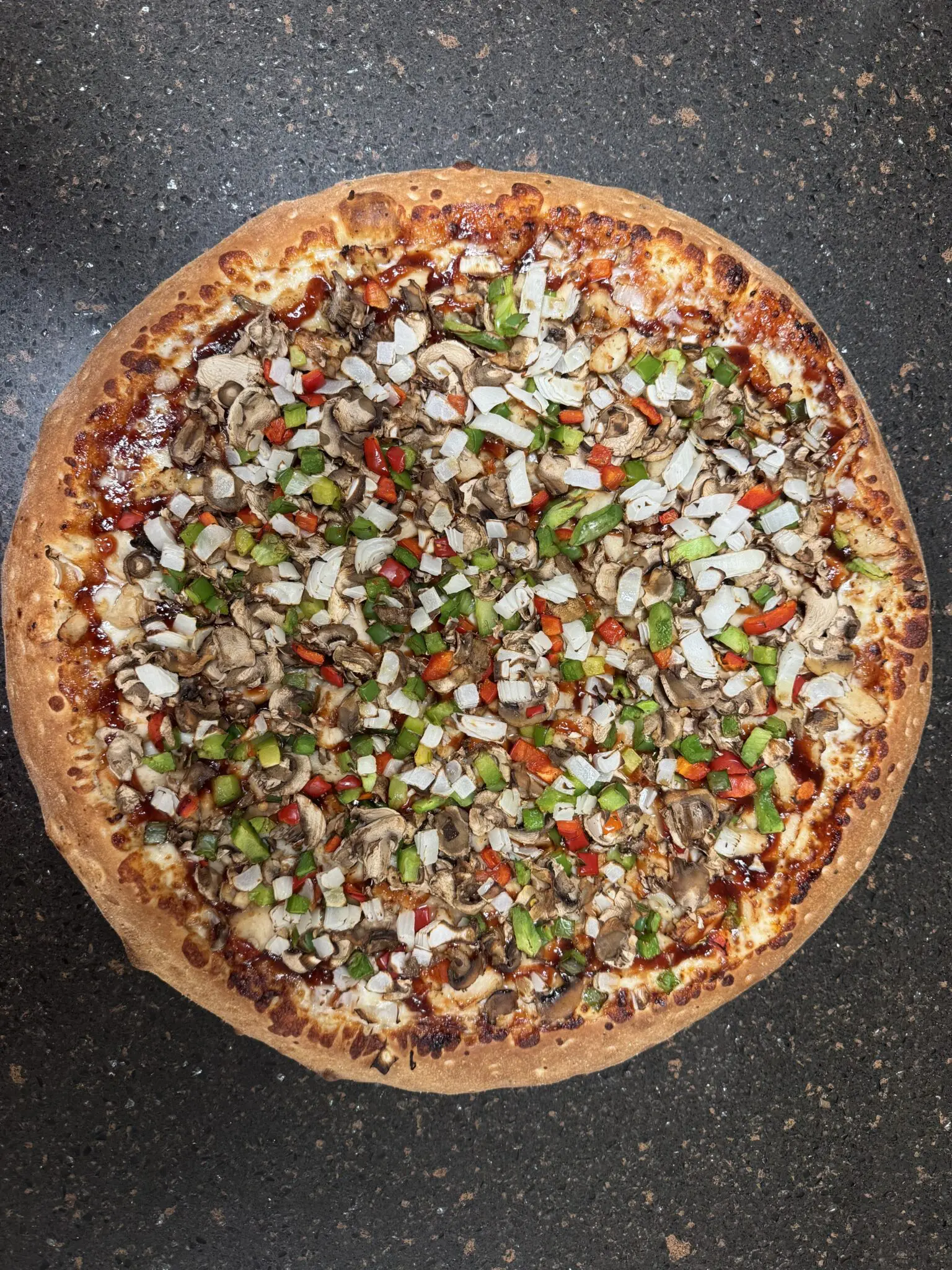 A pizza topped with onions, green peppers, and possibly ground meat.