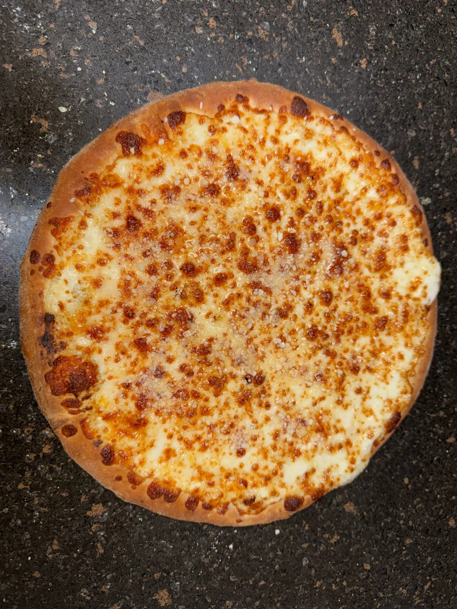 A whole cheese pizza with a golden, bubbly crust.