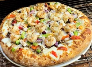 A shrimp pizza topped with vegetables and melted cheese.