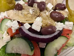 Close-up of a fresh Greek salad with olives, feta, cucumber, and red onion.