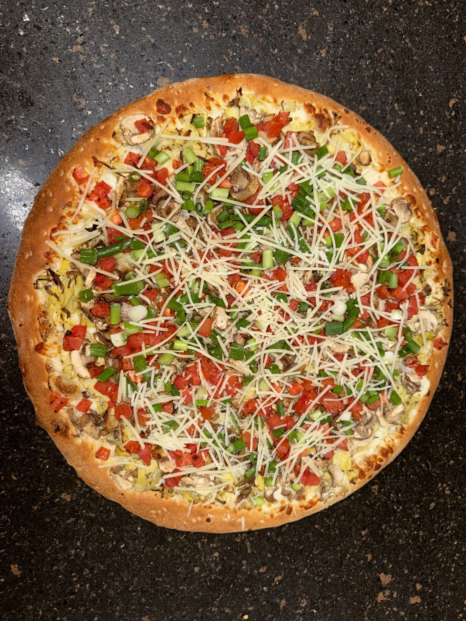 A delicious pizza topped with cheese, tomatoes, and fresh herbs.
