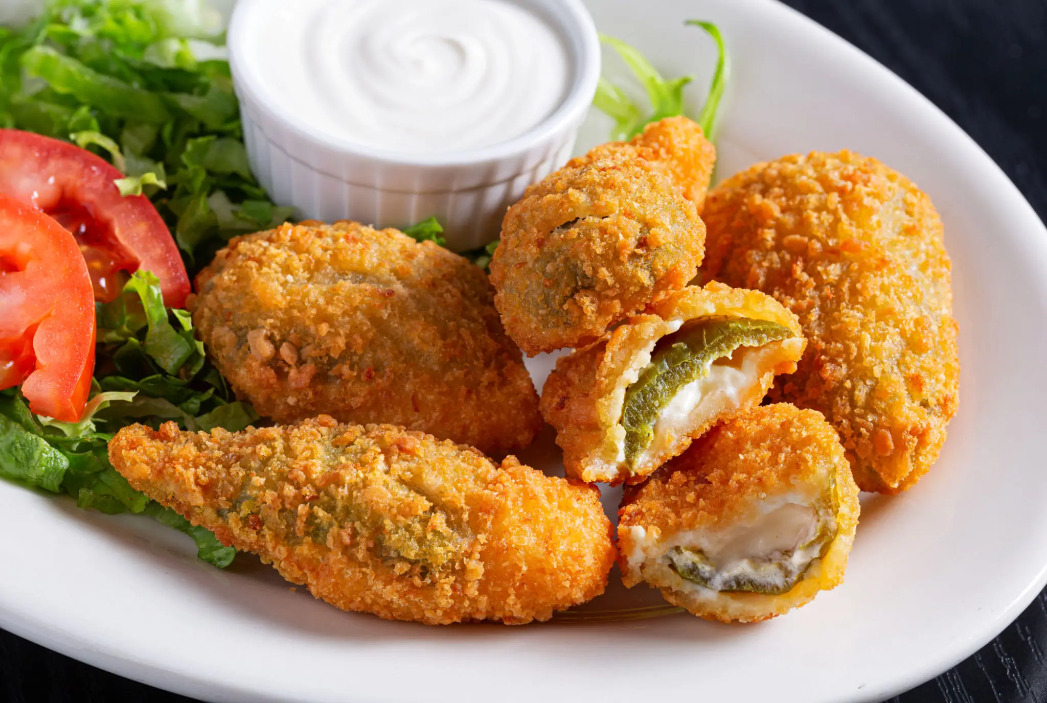 Crispy fried jalapeño poppers with dipping sauce.