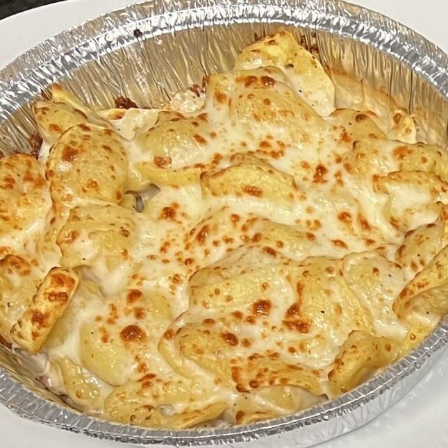 Baked cheesy pasta in a foil container.