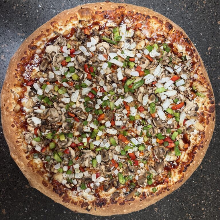 A pizza topped with onions, green peppers, and possibly ground meat.
