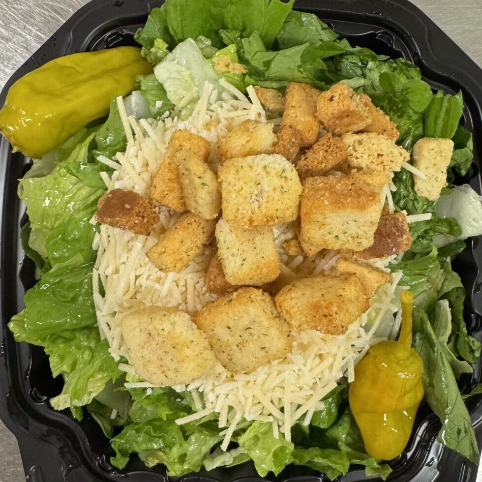 Caesar salad with lettuce, croutons, shredded cheese, and pepperoncini peppers.