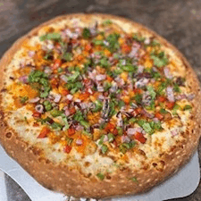 A colorful vegetable pizza with olives, tomatoes, and herbs on a golden crust.