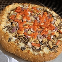 Homemade pizza topped with diced tomatoes and mushrooms.