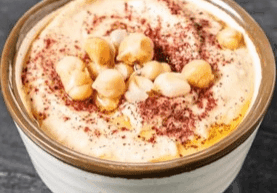 Creamy soup topped with chickpeas and spices in a ceramic bowl.