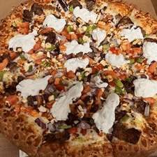 A pizza topped with dollops of white sauce and various toppings.