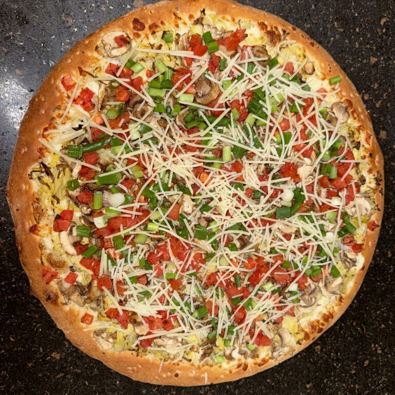 A delicious pizza topped with cheese, tomatoes, and fresh herbs.